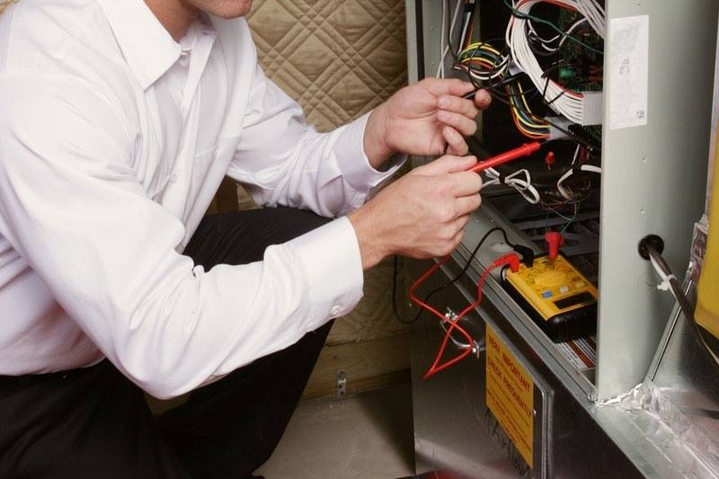 Close view of a technician fixing a furnace.