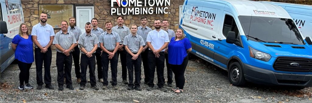 The Hometown Plumbing team standing next to a fleet vehicle.